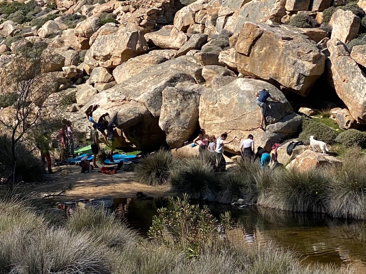 Group at the bottom of boulders in front of a river