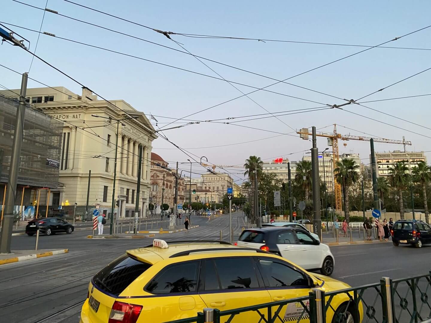Taxis and cars on the Piraeus roads with tram cables overhead