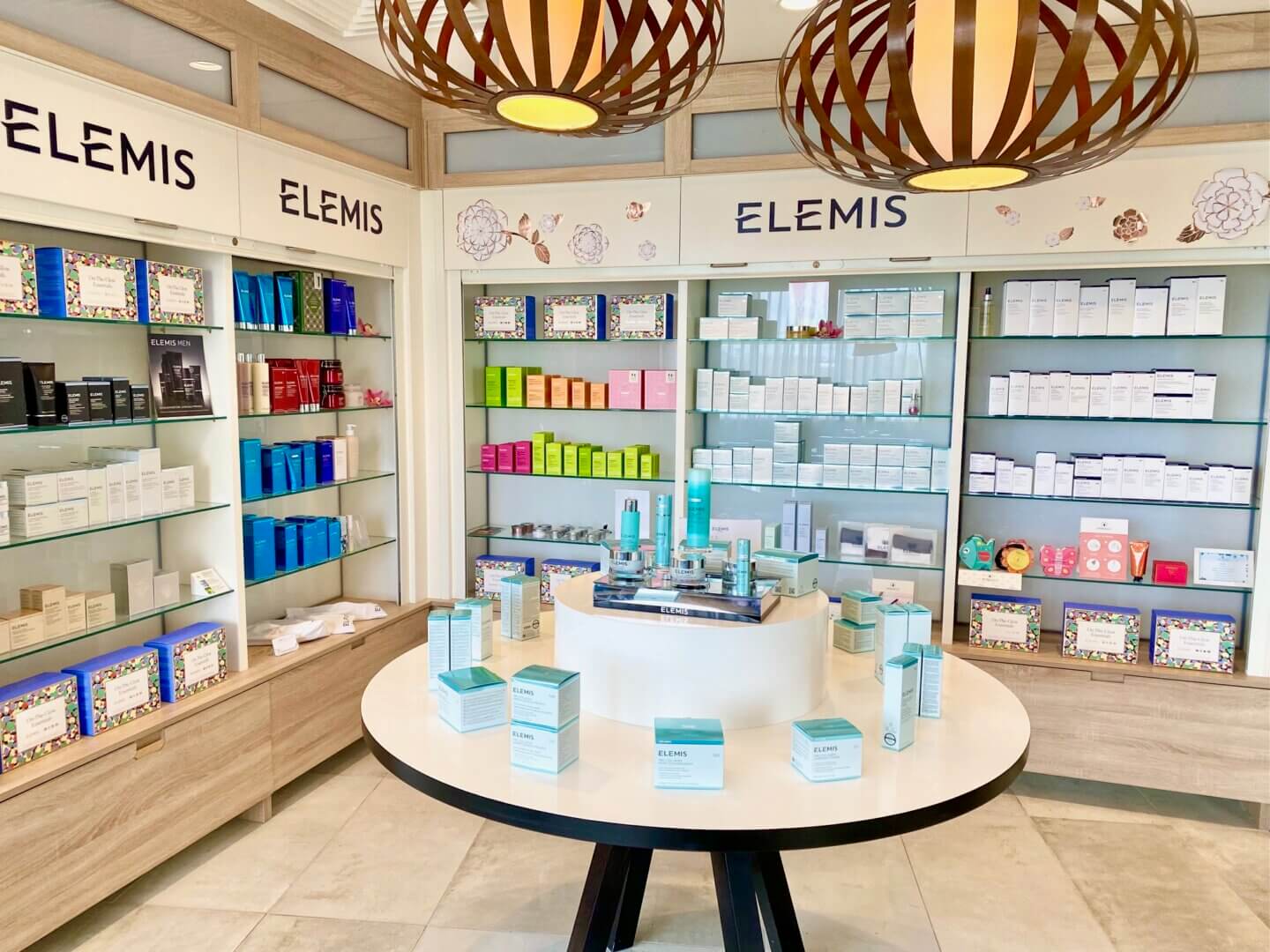 Display of Elemis beauty products on a round table and shelving